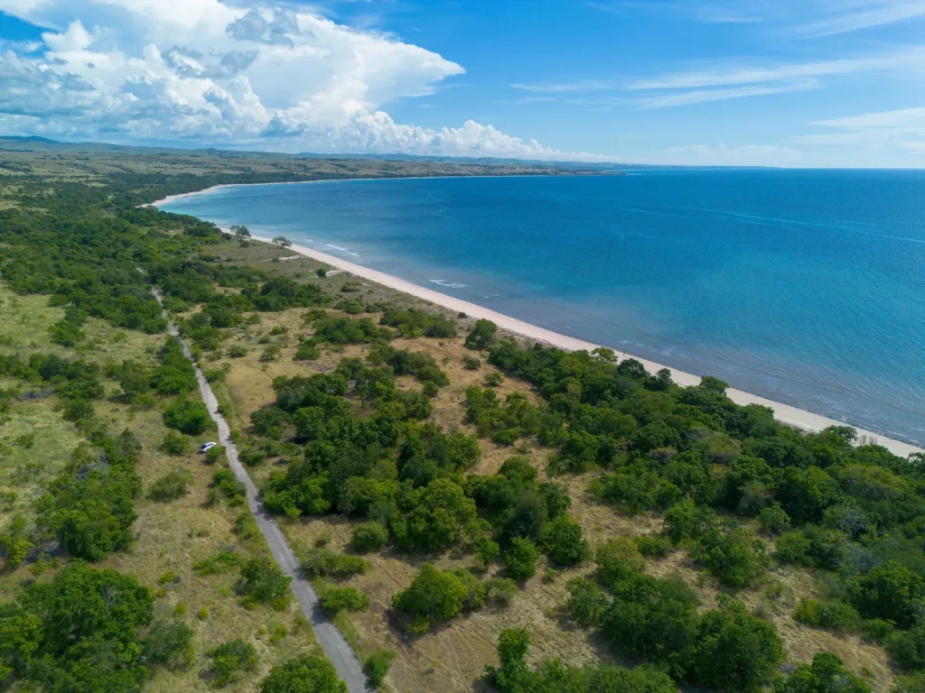 Long beachfront and green fields viewed from above at Lenang Beachfront, Lenang, Central Sumba